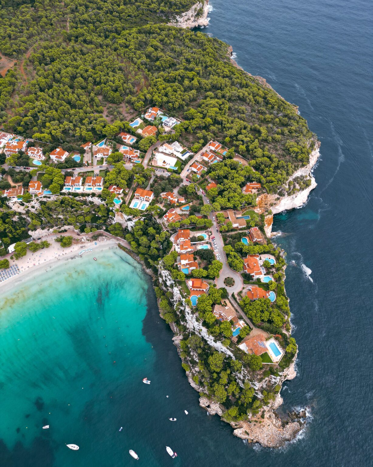 Explore the breathtaking aerial view of Cala Galdana, showcasing its turquoise waters and lush greenery.