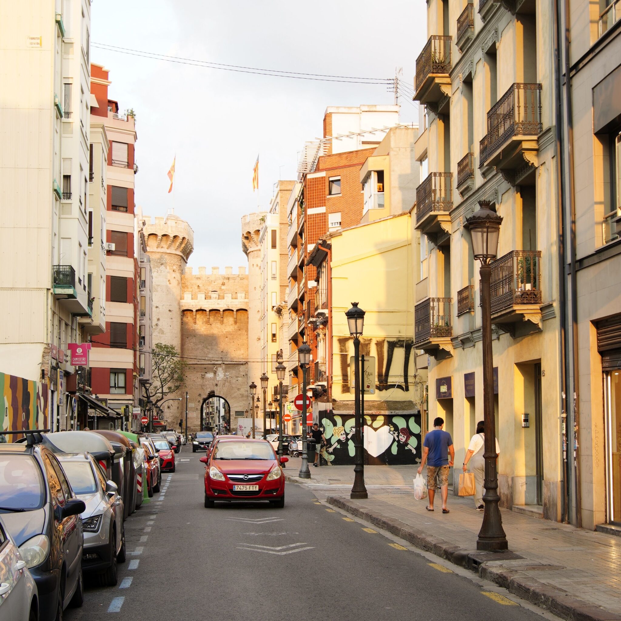 A scenic view of a busy street leading to the historic Torres de Serranos in Valencia, Spain.