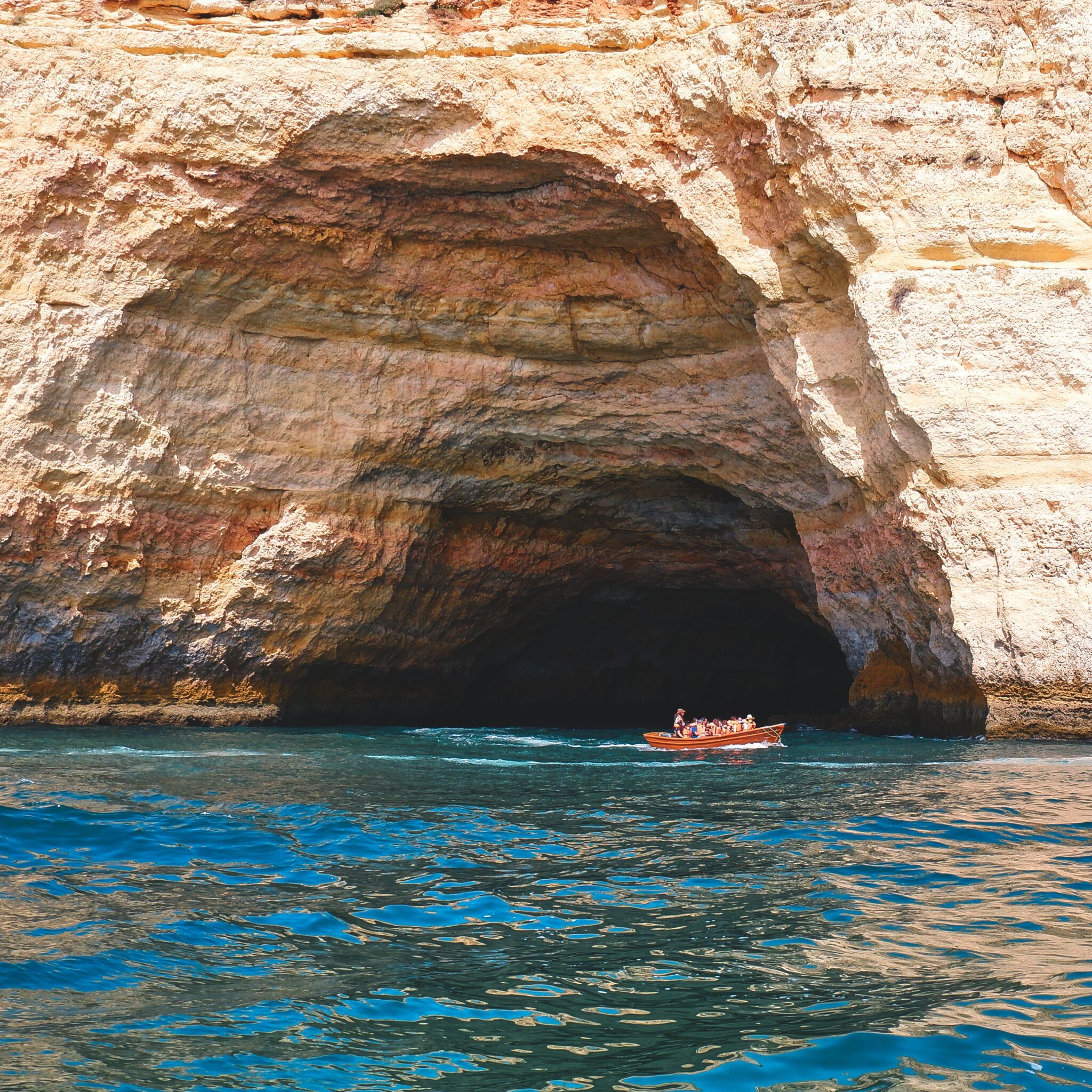 Explore the stunning Algarve rock formations during a sunny boat tour along Portugal's coast.